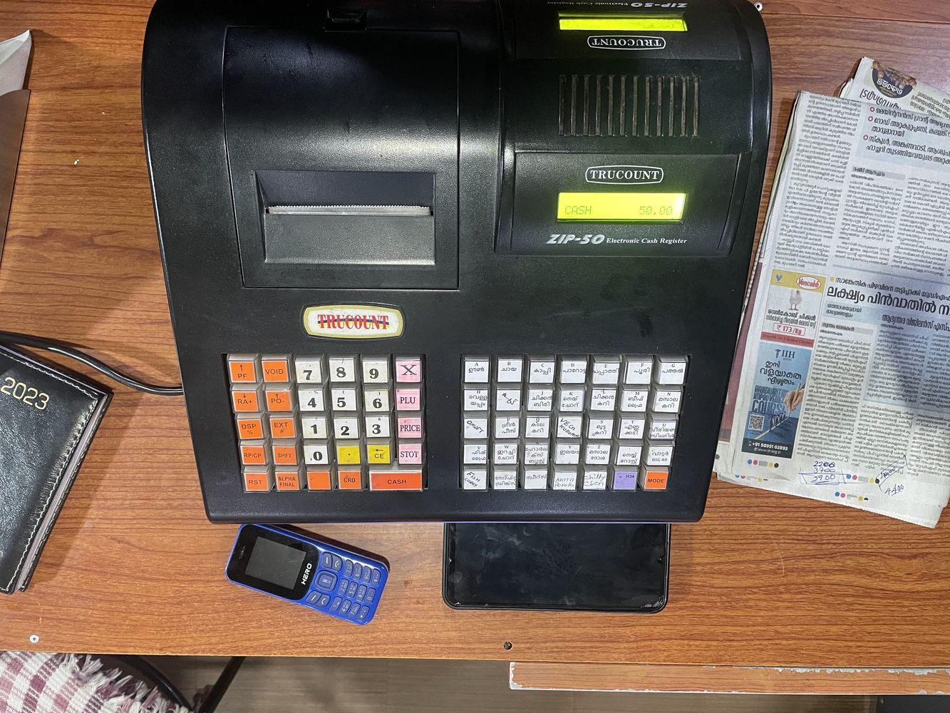 A cash register in a local restaurant with custom Malayalam labels.